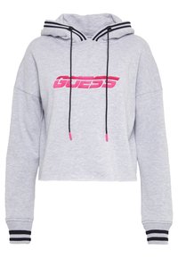 Felpa corta grigia in morbido materiale con accenti a righe bianche e nere, dotata di un logo stilizzato in rosa "GUESS" sul davanti.