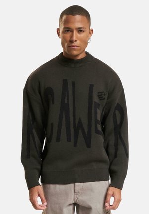 Dark green knit sweater with oversized black lettering, ribbed collar and cuffs, loose fit, and a textured finish.