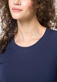 T-shirt bleu marine à manches courtes avec un col rond. Fabriqué en tissu lisse avec un design simple et sans motifs ni embellissements visibles.