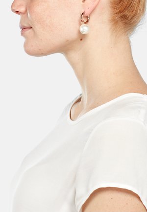 Große, runde Perlenohrringe mit einem Roségold-Hoop. Glatte Oberfläche und reflektierende Textur, die zu einem schlichten weißen Oberteil passen.