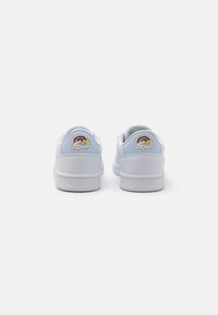 Sneakers bianchi con una texture liscia. Accenti blu sul tallone con un design di arcobaleno e sole. Suola in gomma flessibile per il comfort.