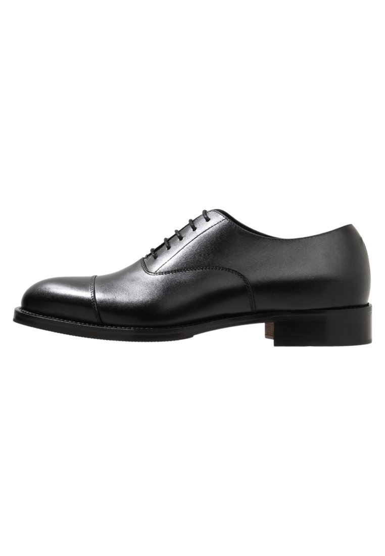 Chaussure Oxford en cuir noir avec une finition lisse, un bout rond et cinq œillets pour les lacets. Elle présente un talon bas empilé et des détails cousus.