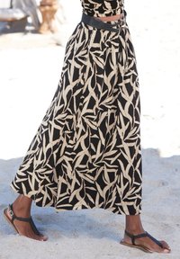 Črna dolga krila z svetlobezžasto listno vzorcem, nabran pas in črn pas. Oblečeno z črnimi tkanimi sandalami na peščenem terenu.