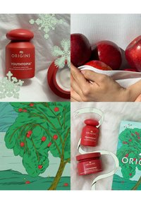 Tarro rojo etiquetado "YOUTHTOPIA" de Origins, con una tapa redonda. Los elementos circundantes incluyen manzanas y un fondo ilustrado en color verde.