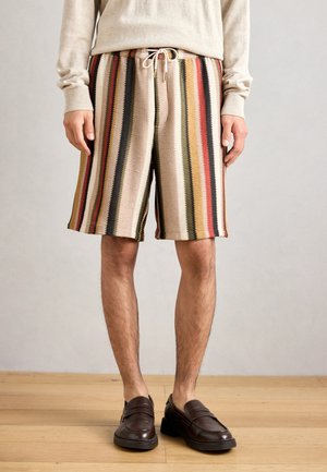 Strickshorts mit vertikalen, mehrfarbigen Streifen: beige, rot, grün und schwarz. Mit einem Kordelzugbund und lockerer, knielanger Passform.