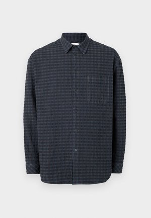 Camicia button-up blu scuro con un motivo a griglia testurizzato, maniche lunghe, colletto e taschino sul petto con bottoni abbinati.