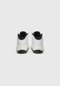 White athletic shoes with a smooth upper, black accents at the heel and collar, textured sides, and a black rubber sole.