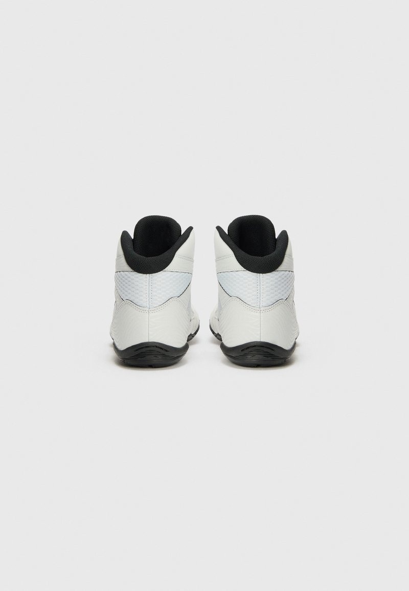 White athletic shoes with a smooth upper, black accents at the heel and collar, textured sides, and a black rubber sole.