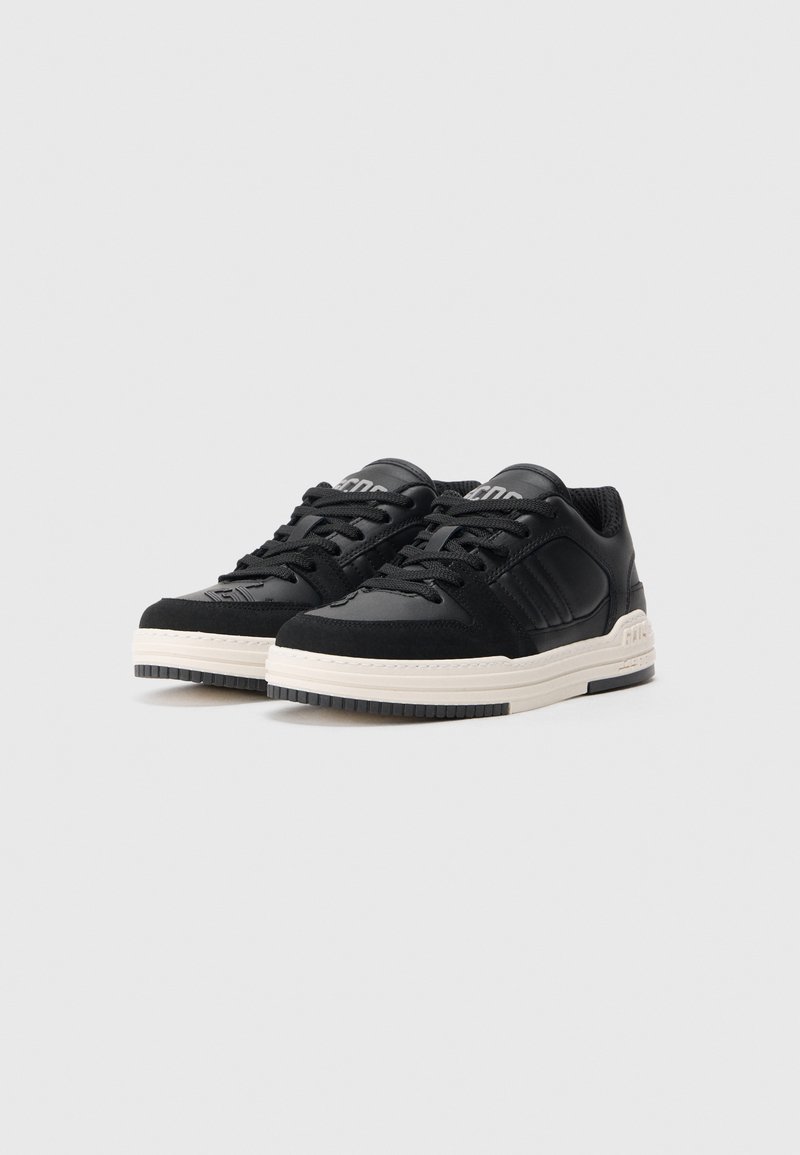 Black sneakers with suede and leather upper, textured black laces, white midsole, and rubber outsole. Features subtle branding on tongue.