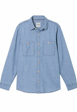 Lyseblå langærmet skjorte i denim med knapper, to brystlommer og brune knapper. Har klassisk krave og buet kant.