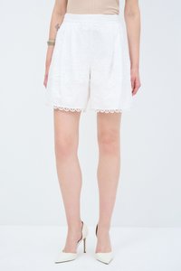 Pantalones cortos blancos bordados con un dobladillo en forma de concha, que presentan patrones florales. Fabricados con un tejido ligero, diseñados con un frente plisado.