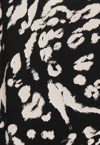 Tessuto nero con un audace motivo astratto di stampa leopardata crema, caratterizzato da vari texture e forme a pennellate.