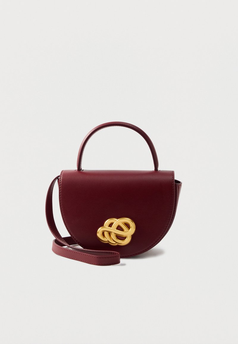 Borsa a tracolla in pelle bordeaux con forma arrotondata, caratterizzata da un dettaglio a nodo dorato sul davanti e una tracolla removibile.
