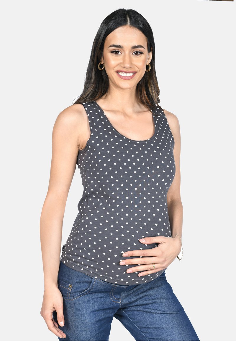 Graues Tanktop mit weißen Herzmustern, ärmelloses Design, Rundhalsausschnitt und weichem Material, kombiniert mit blauen Jeans.