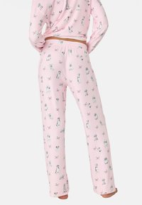 Rosa pyjamaset med ett mönster av olika hundillustrationer och fjärilar. Tillverkat av mjukt tyg, med en bekväm passform och elastisk midja.