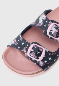 Παιδικές σαγιονάρες με ναυτικό άνω μέρος που διαθέτει σχέδιο με μονόκερους και αστέρια, δύο ροζ ρυθμιζόμενους κλειστούς, και ροζ υφασμάτινη σόλα.