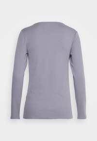 T-shirt de mangas compridas em roxo claro, com decote redondo e corte justo, fabricado em um material suave e elástico. Sem logótipos ou padrões visíveis.