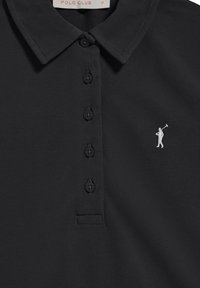 Svart polo skjorta med en texturerad tyg, tre knappslå, och en liten vit broderad figur som håller en golfklubba på vänster bröst.