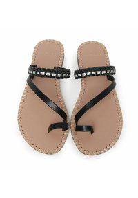 Sort flade sandaler med en flettet rem, der har metalskær, en lysebrun fodseng og dekorativ syning langs kanterne.