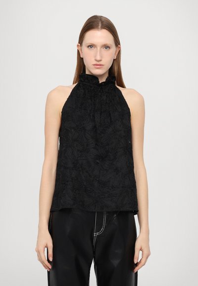 Crni halter top s teksturiranim cvjetnim uzorkom i naboranim izrezom. Uparen s crnim hlačama s kontrastnim bijelim šavovima.