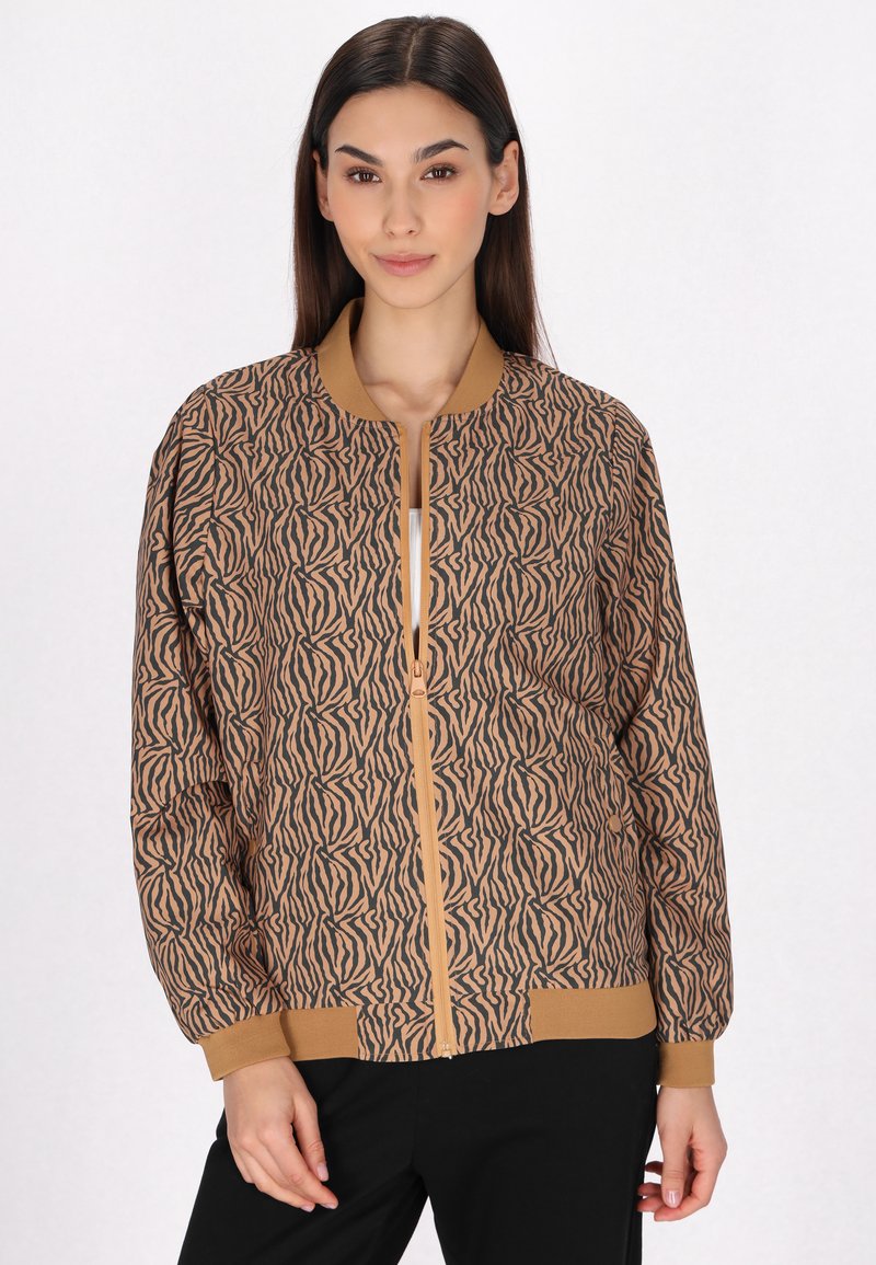 Giacca bomber marrone con un motivo astratto nero, polsi e orlo a costine, e chiusura centrale con zip. Tessuto liscio, vestibilità rilassata.