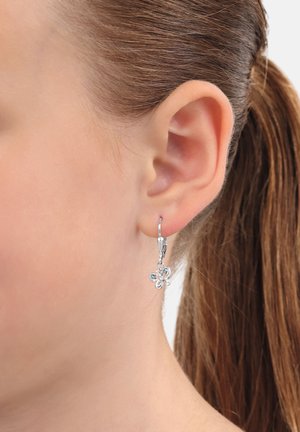 Orecchini a goccia floreali in argento con design ad amo. Il fiore presenta dettagli intricati e una finitura lucida, pendendo appena sotto il lobo dell'orecchio.