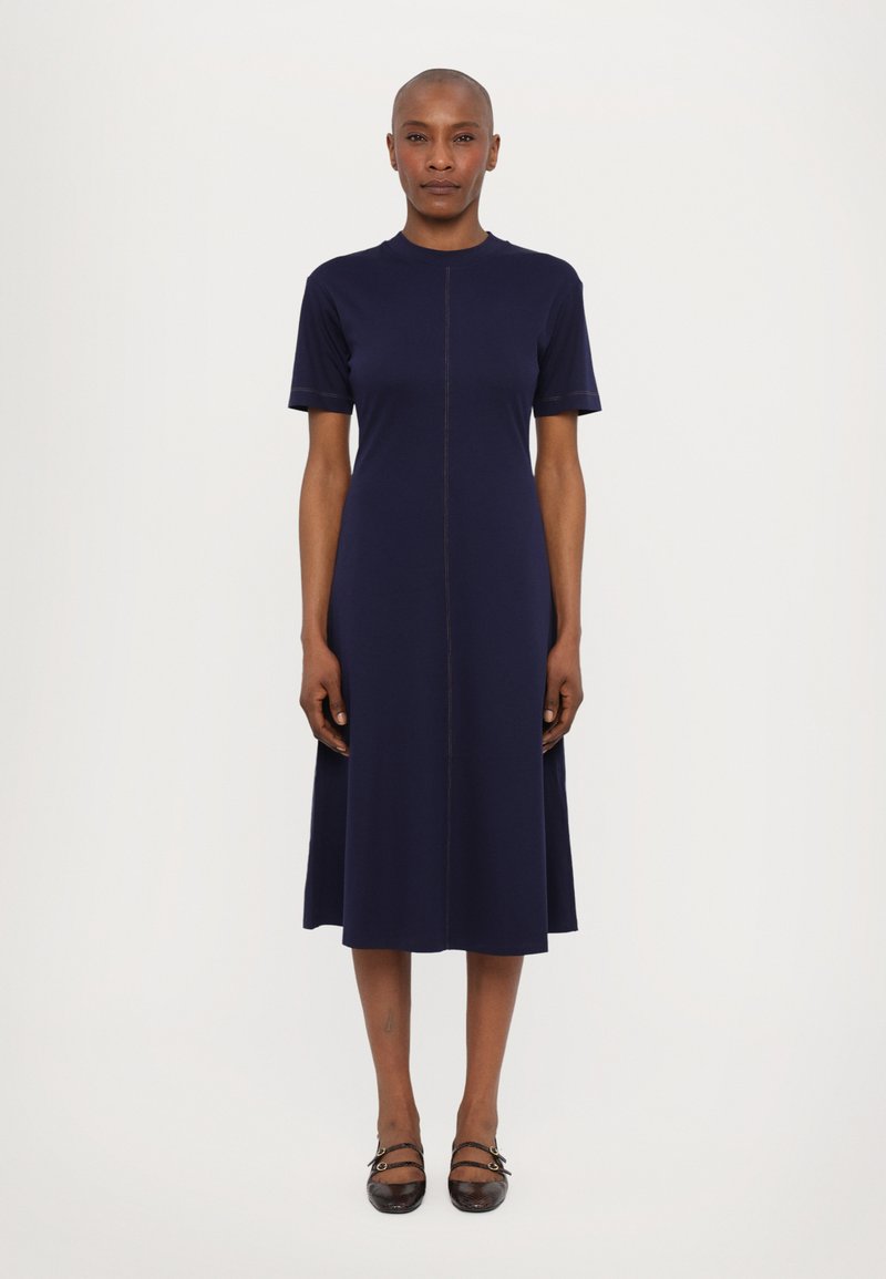 Marineblaues Midikleid mit kurzen Ärmeln, einem runden Ausschnitt und einer zentralen Naht. Hergestellt aus einem glatten Stoff, der dezente kontrastierende Nähte aufweist.