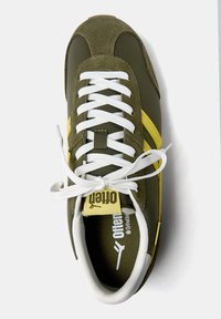 Zöld velúr és hálós sneaker fehér cipőfűzőkkel, sárga kiemelésekkel és márkázott nyelvlabellel. Lekerekített orr és párnázott talp.