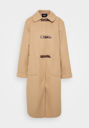 Beige uldfrakke med rund krave, lange ærmer og to forlommer. Lukkes med tre mørkebrune toggle-lukninger.