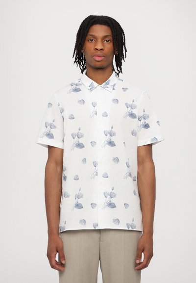 White short-sleeve shirt featuring a blue floral pattern, button-down collar, and lightweight fabric, paired with light-colored trousers.