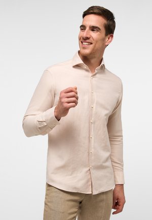 Light pink button-up shirt with a collar, long sleeves, and a smooth texture. Plain design with double-button cuffs and a subtle sheen.