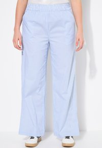 Pantalons larges à rayures bleu et blanc avec une taille élastique. Fabriqués en tissu léger, offrant une texture lisse et une coupe décontractée.