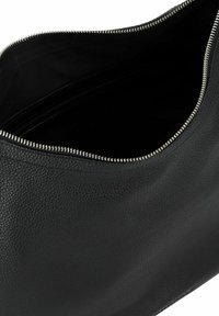 Czarna skórzana torba o teksturowanej powierzchni, z zamkiem błyskawicznym oraz przestronnym wnętrzem wyłożonym czarnym materiałem.