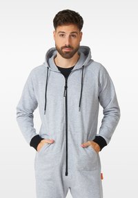 Sivý mikina na zips s čiernymi akcentmi, obsahujúci predný zips, vrecká a textúrovanú tkaninu pre pohodlie. Mikina s nastaviteľnými šnúrkami.