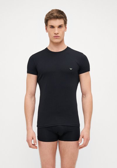 Zwarte fitted t-shirt en zwarte boxershorts, korte mouwen, ronde halslijn, gladde textuur, met een klein groen logo op de borst.