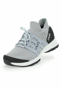 Hellgraue Sportschuhe mit einem gestrickten Obermaterial, schwarzen Akzenten, flachen Schnürsenkeln, einer gepolsterten Sohle und strukturierten Bereichen für Grip und Unterstützung.