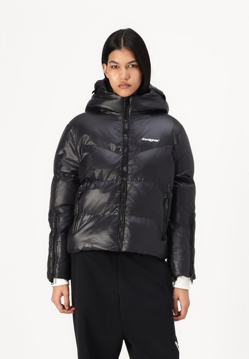 Black puffer jacket with a glossy finish, zippered front, and hood. Features diagonal quilted design and side zip pockets.
