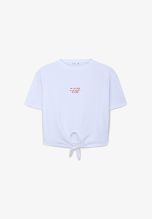 Maglietta corta bianca in cotone con maniche corte, caratterizzata da un dettaglio annodato sul fondo e testo rosso sulla parte anteriore che recita "UN DELIRIO ALLA VOLTA GRAZIE."