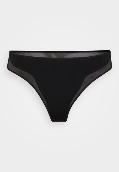 String noir fabriqué à partir d'un tissu lisse avec des panneaux latéraux en maille transparente, arborant un design minimaliste et une ceinture élastique.