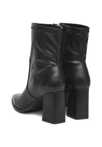 Para czarnych skórzanych botków sięgających do połowy łydki, z szerokimi obcasami i tylnymi zamkami błyskawicznymi, widziana z tylno-prawiej strony.