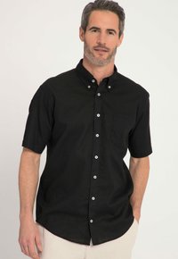 Zwart kortarm overhemd met een button-down kraag, een borstzak en witte knopen. Gemaakt van een glad materiaal, iets losvallend.