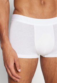 Fehér pamut boxer alsónadrág puha, elasztikus derékpánttal, amelyen a Levi's logó található. Simaság, testhezálló kialakítás és combközép hosszúság.