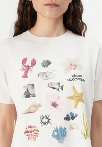 Bílý bavlněný tričko s ilustracemi na téma oceánu: humr, mušle, ryby, hvězdice a květinové vzory s textem "trésors océaniques".