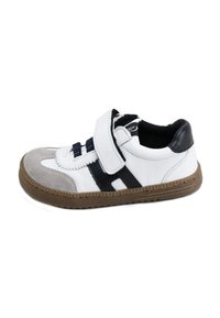 Zapatilla blanca de cuero con acentos en negro y gris, que cuenta con una correa de Velcro y una suela de goma texturizada. Cuello ligeramente acolchado para mayor comodidad.
