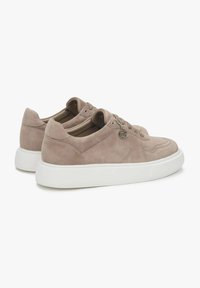 Zamszowe sneakersy w jasnym taupe z białą gumową podeszwą. Charakteryzują się sznurowanym zapięciem, perforowanymi detalami oraz akcentującą pętlą z metalu.
