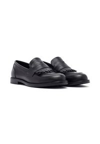 Mocassins en cuir noir avec une finition à franges à l'avant, un talon bas et empilé, ainsi qu'une texture lisse. Le design est minimaliste et classique.