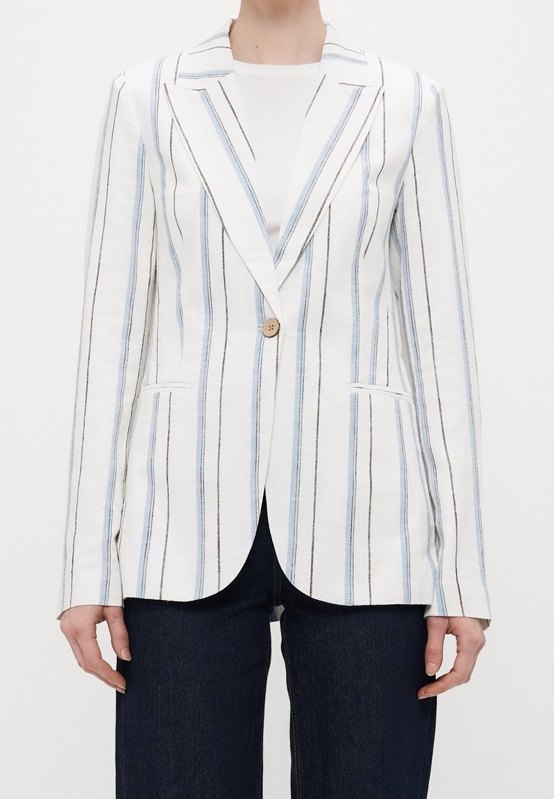 White linen blazer with vertical blue and brown stripes, single button closure, notch lapels, and side pockets. Worn over a white top.