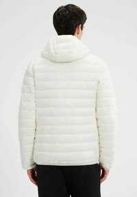 Cazadora acolchada blanca con capucha, con un diseño de rombos, rayas verticales y puños elásticos. Textura suave, ligera y abrigada.
