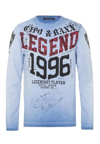 Hellblaues Langarm-T-Shirt mit einem Grafikdruck, der "LEGEND 1996" und zusätzlichen Text zeigt. Es besteht aus einem weichen Stoff mit einer leichten Textur.