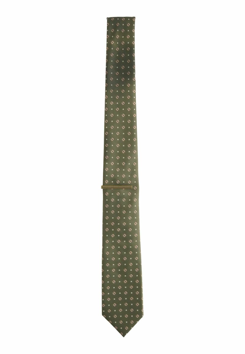 Cravate verte avec une surface texturée et de petits motifs de fleurs blanches. Présente une extrémité pointue et une largeur étroite, adaptée aux tenues formelles.